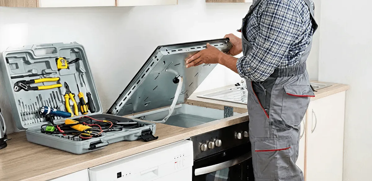 Handyman repairing a cooktop and checking wiring connections in Boulder, CO